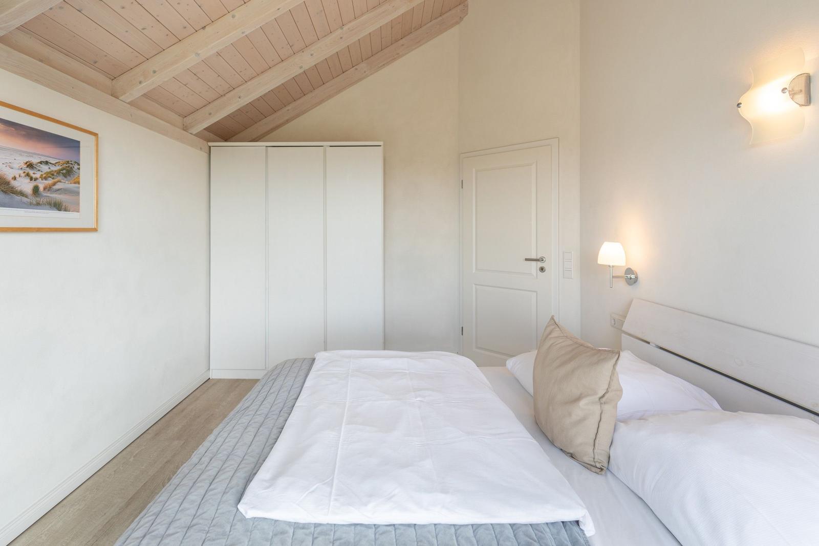 Bedroom with double bed, wardrobe, and wooden ceiling.