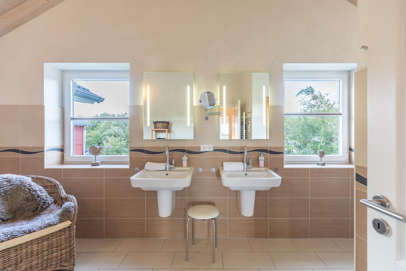 Two sinks with mirrors and windows. Wicker basket with fur blanket.