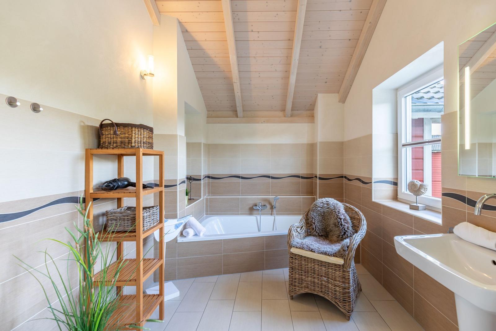 Bathroom with bathtub, sink, and seating area