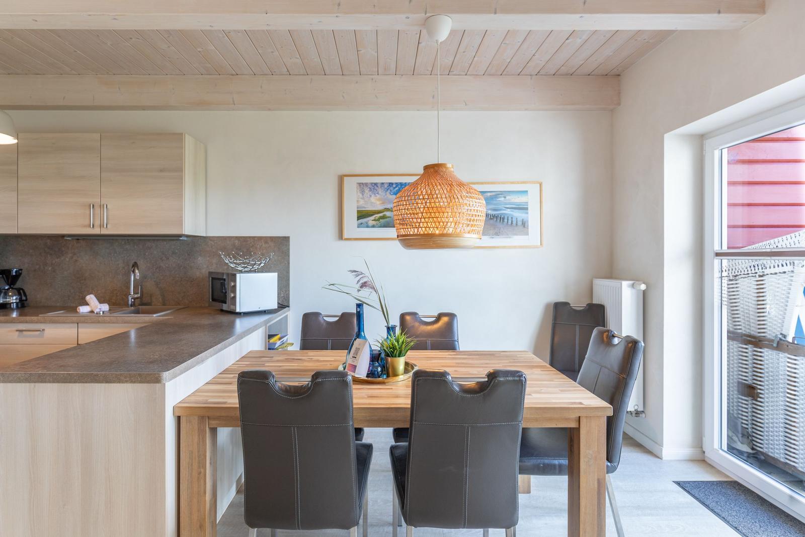 Kitchen with dining area, wooden table, chairs, and ceiling light.