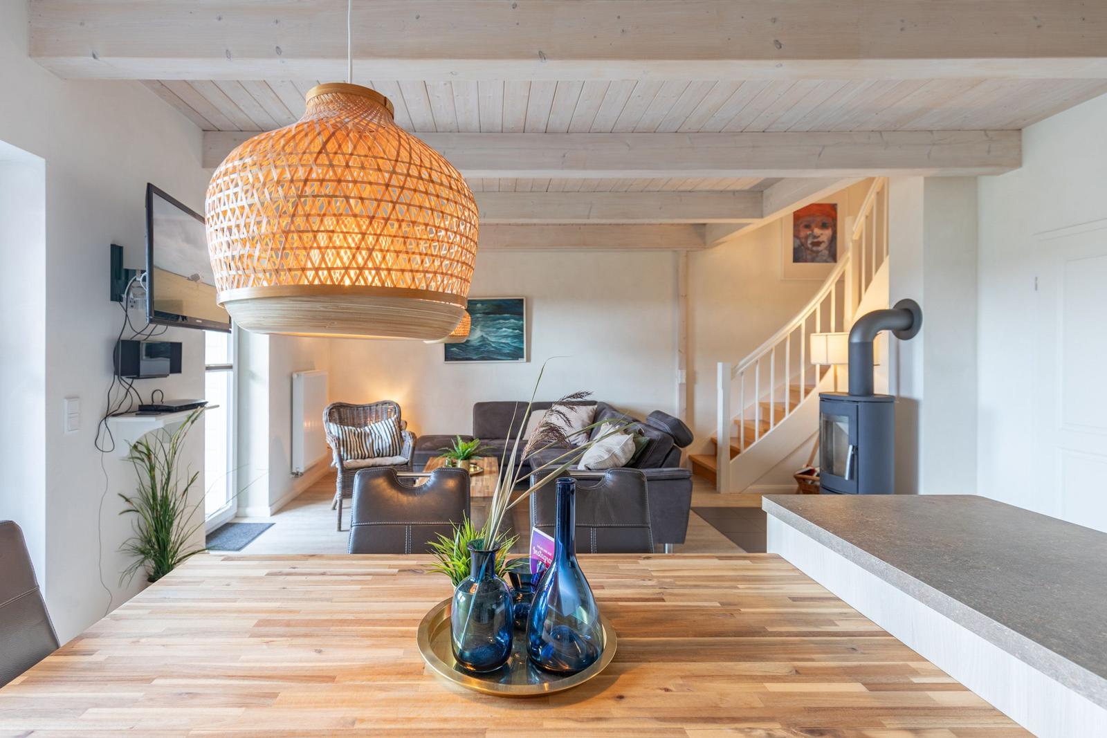 Dining area with wooden table, living area with sofa and wood stove.