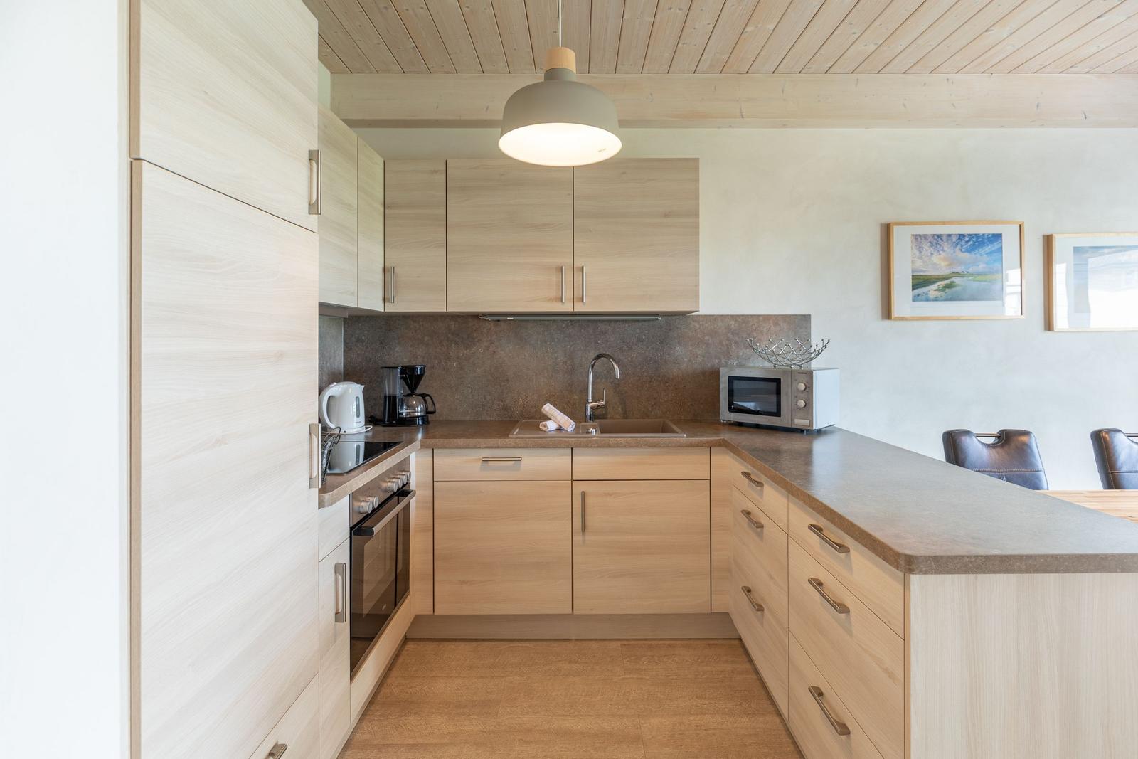 Modern kitchen with wood surfaces, sink, and appliances.