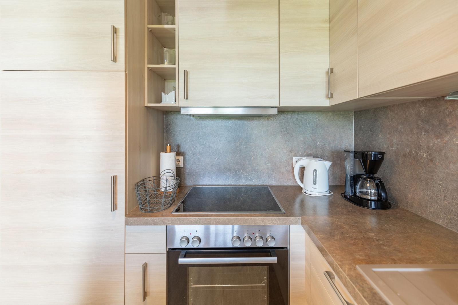 Kitchen with stainless steel stove, coffee maker, and refrigerator.
