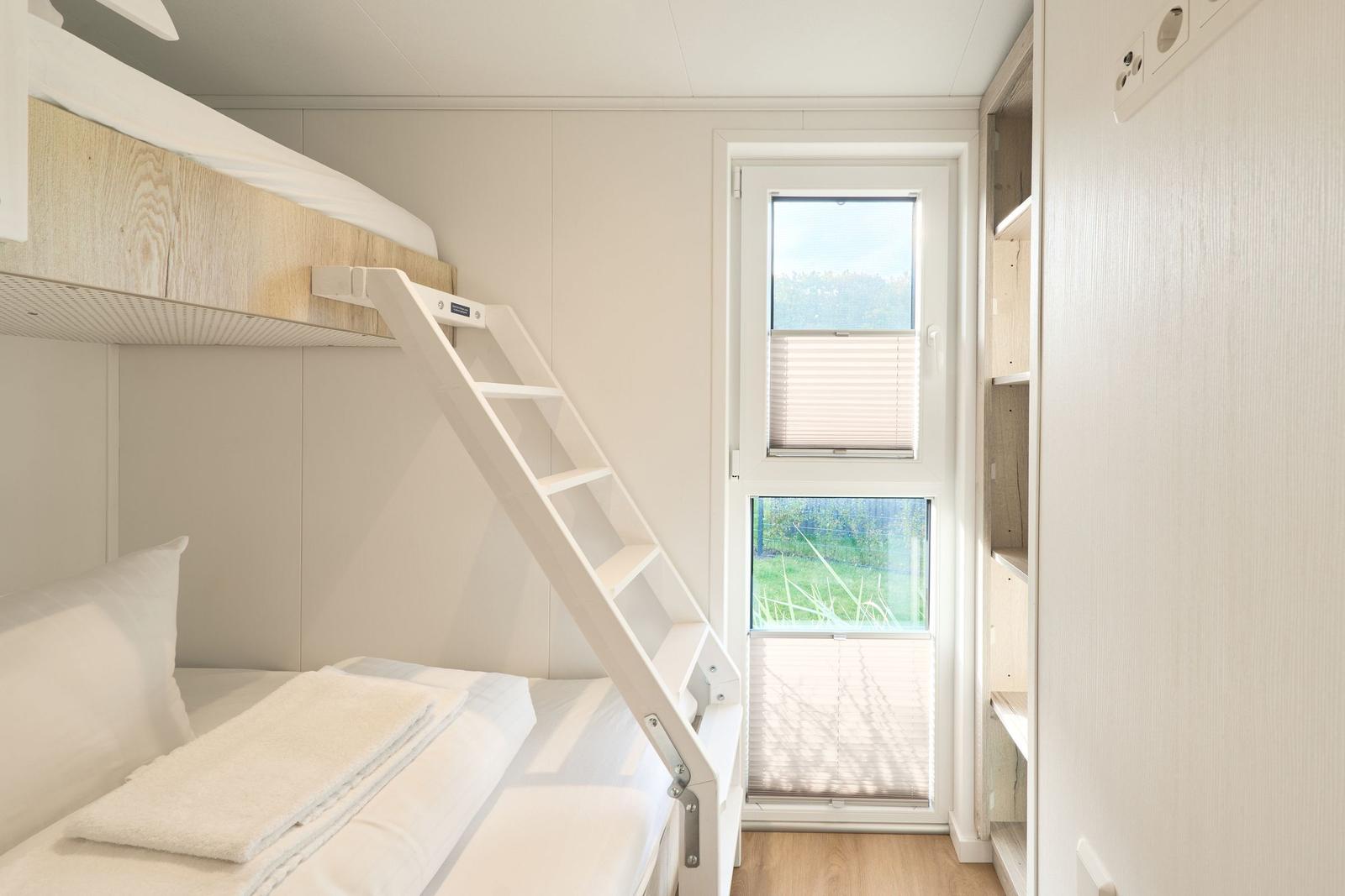 Kabinenbett mit Leiter und Fenster zur Aussicht