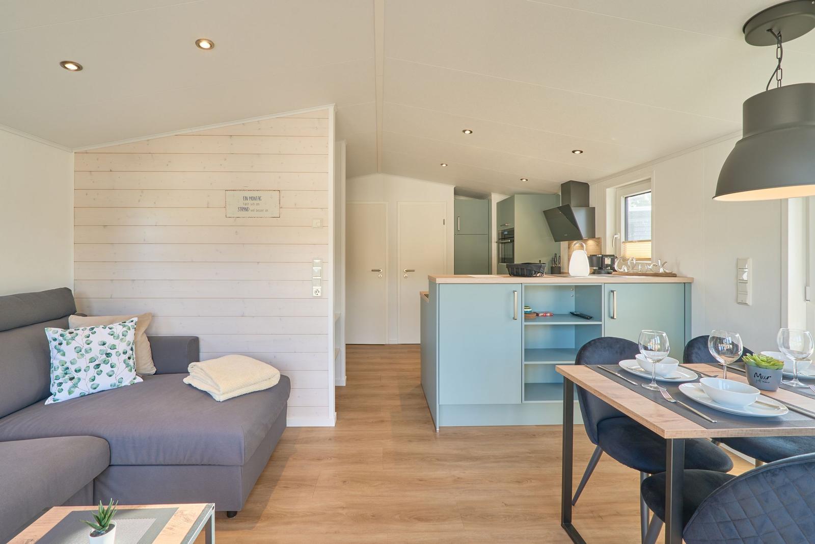 Wohnbereich mit Sofa, Essbereich und Küchenzeile