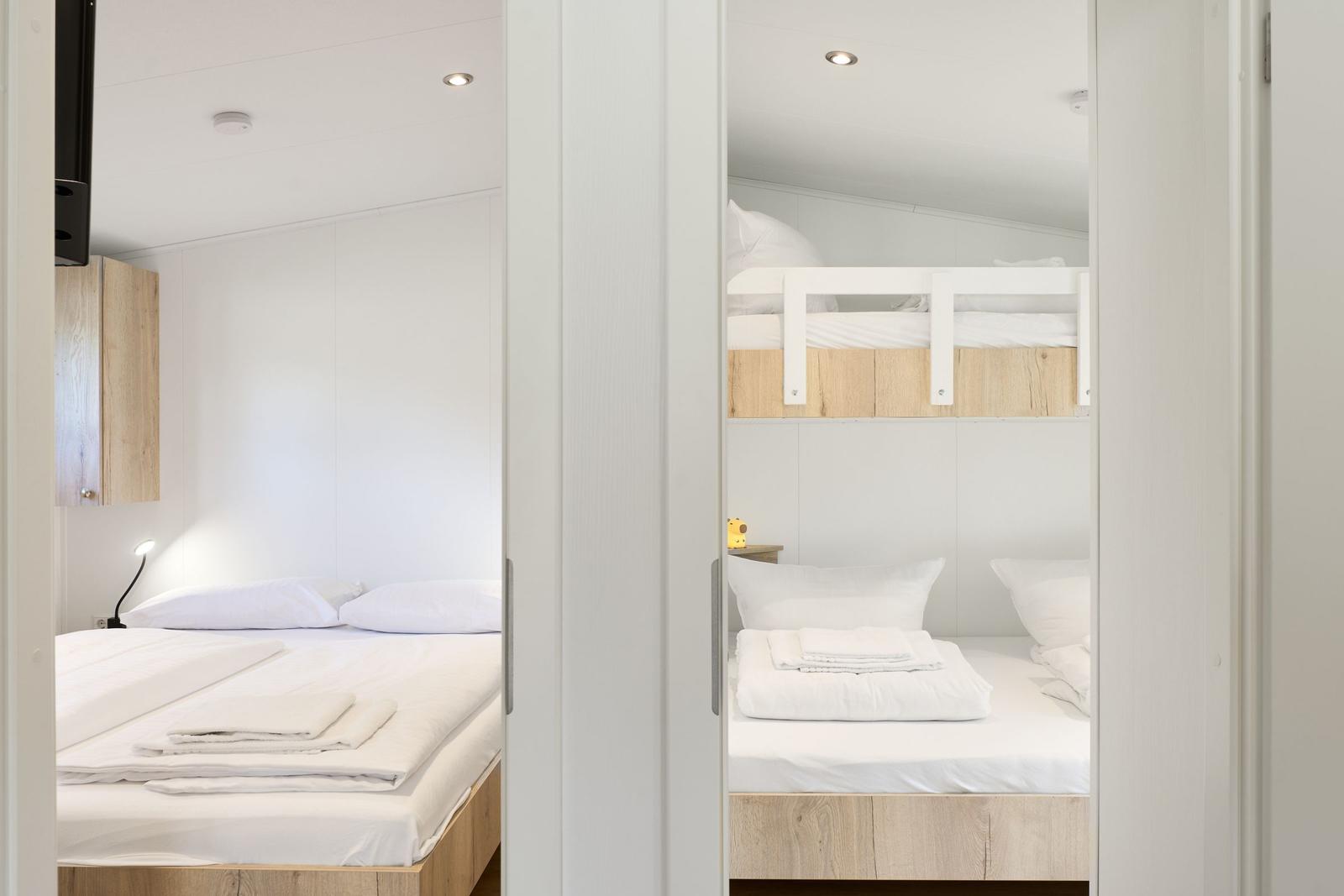 Zwei Schlafzimmer mit Betten und Nachttischen