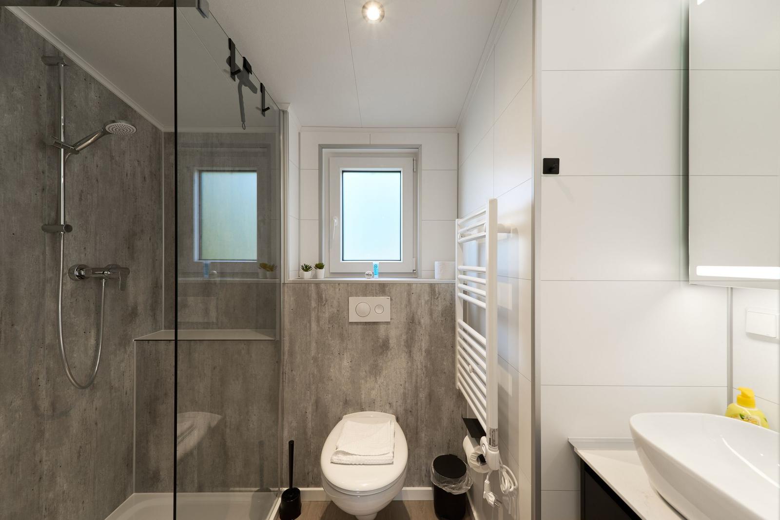 Badezimmer mit Dusche, Toilette und Waschbecken