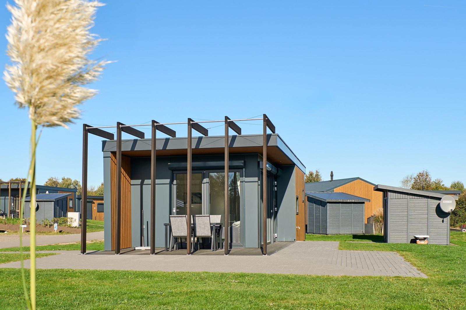 Moderne Unterkunft mit Terrasse und Garten. Sicht auf angrenzende Häuser.