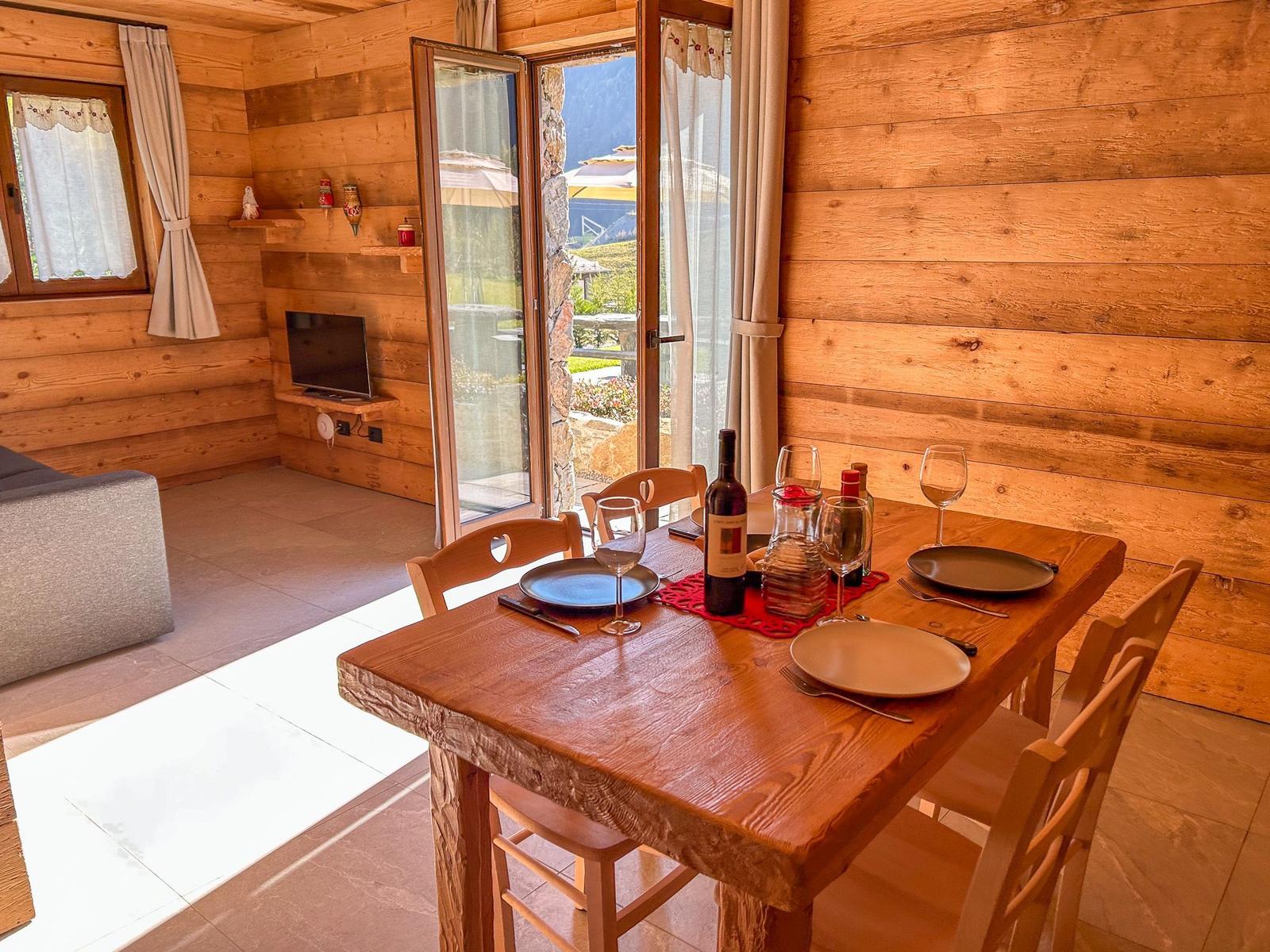 Esszimmer mit Holztisch, Stühlen und Blick auf Terrasse