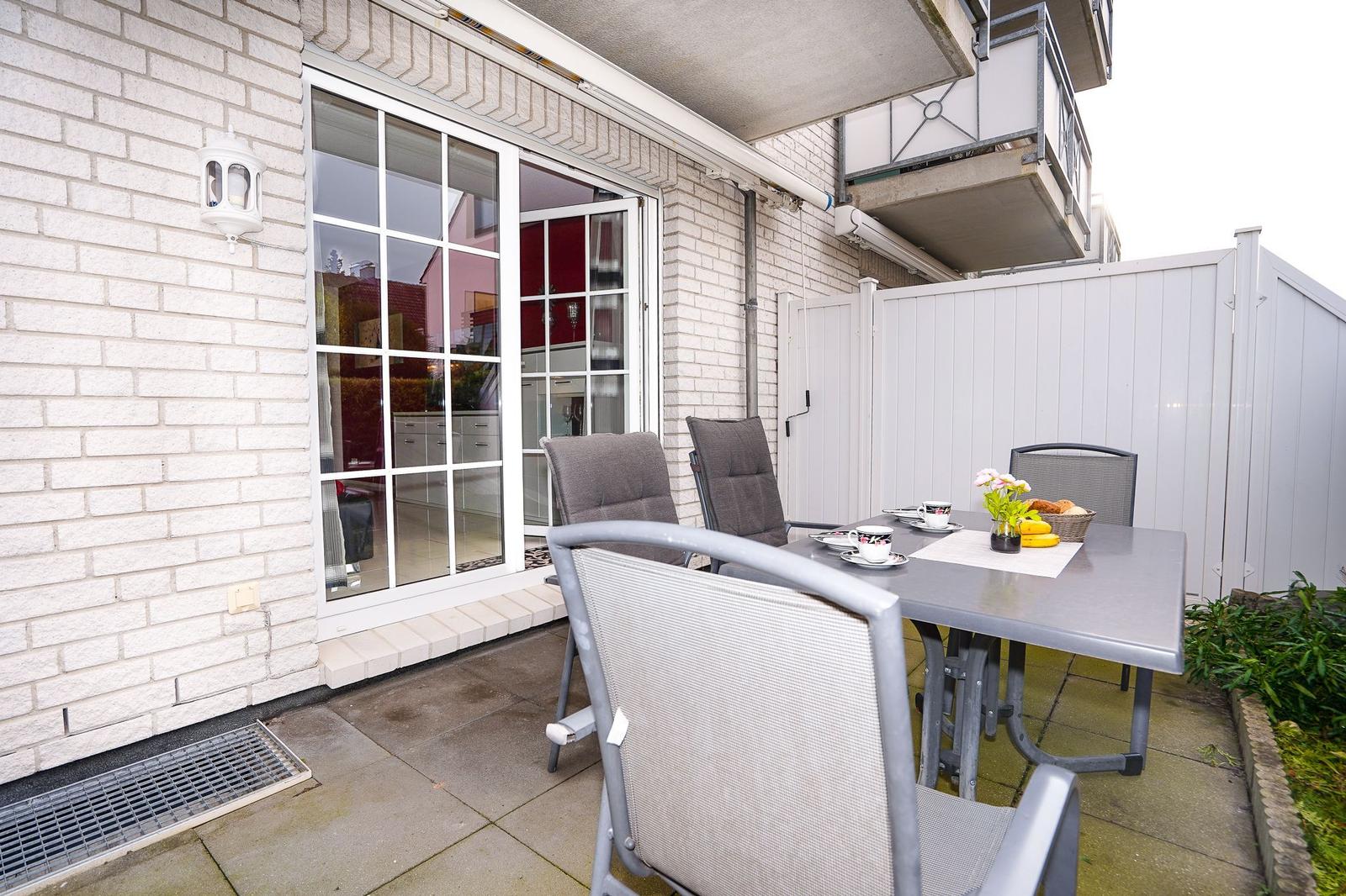 Terrasse mit Tisch, Stühlen und Blick ins Haus