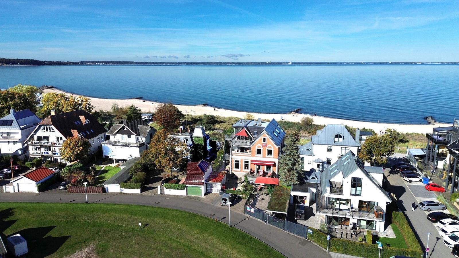 Häuser am Strand mit Blick auf das Wasser und einen Sandstrand.