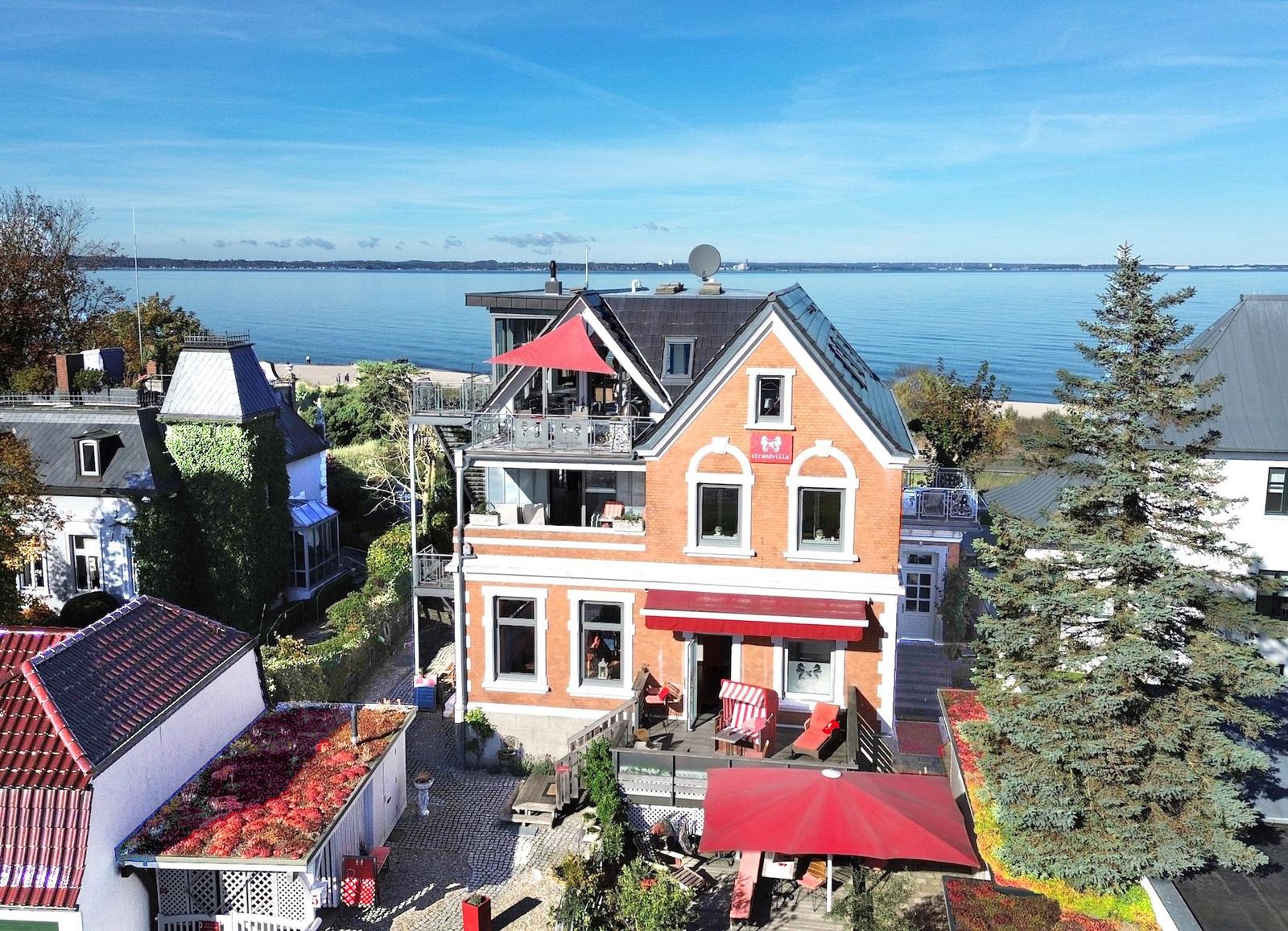 Rotes Backsteinhaus mit Terrasse und Blick aufs Meer.