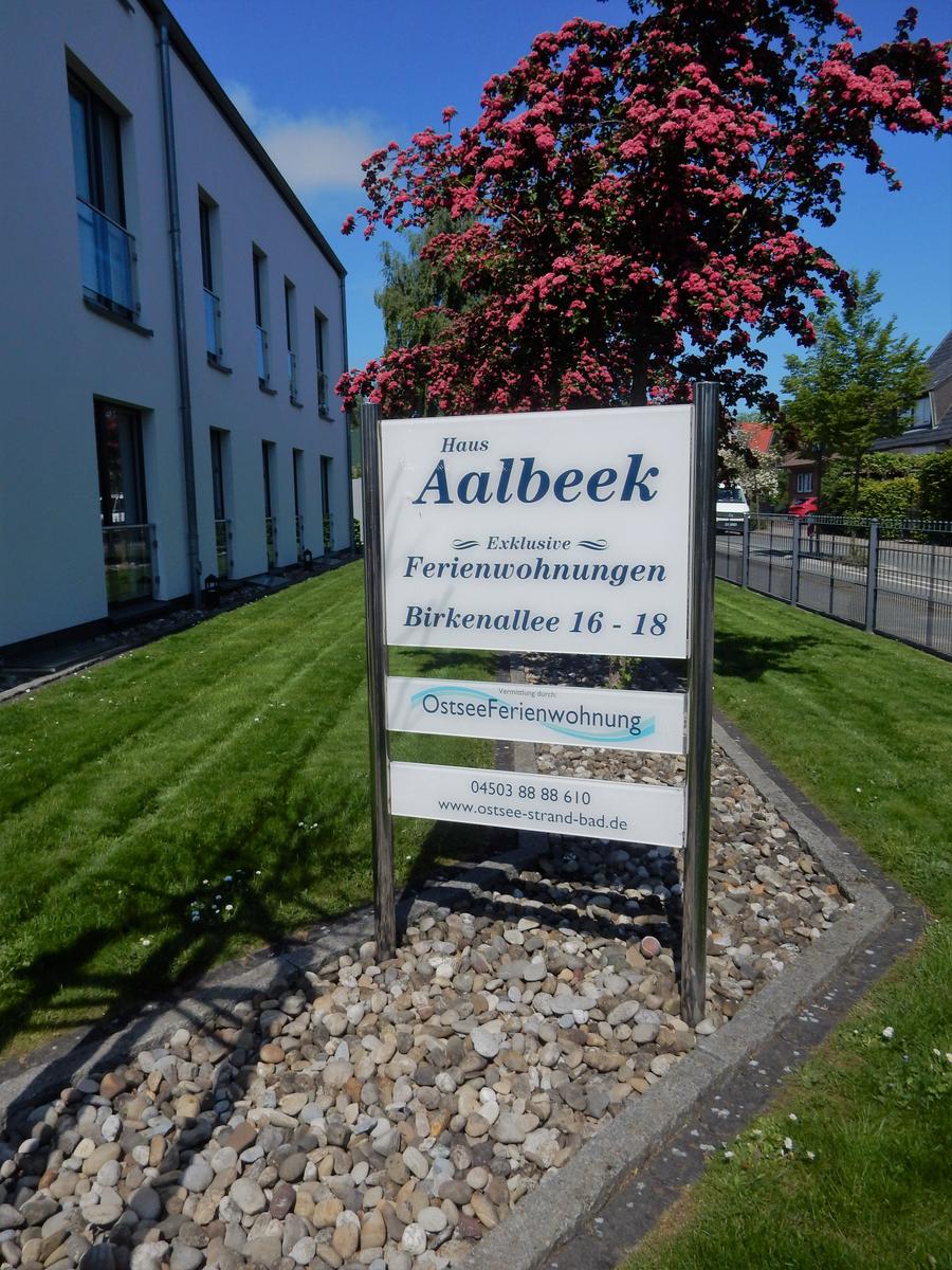 Schild vor Haus Aalbeek mit Ferienwohnungen und Blumenbaum