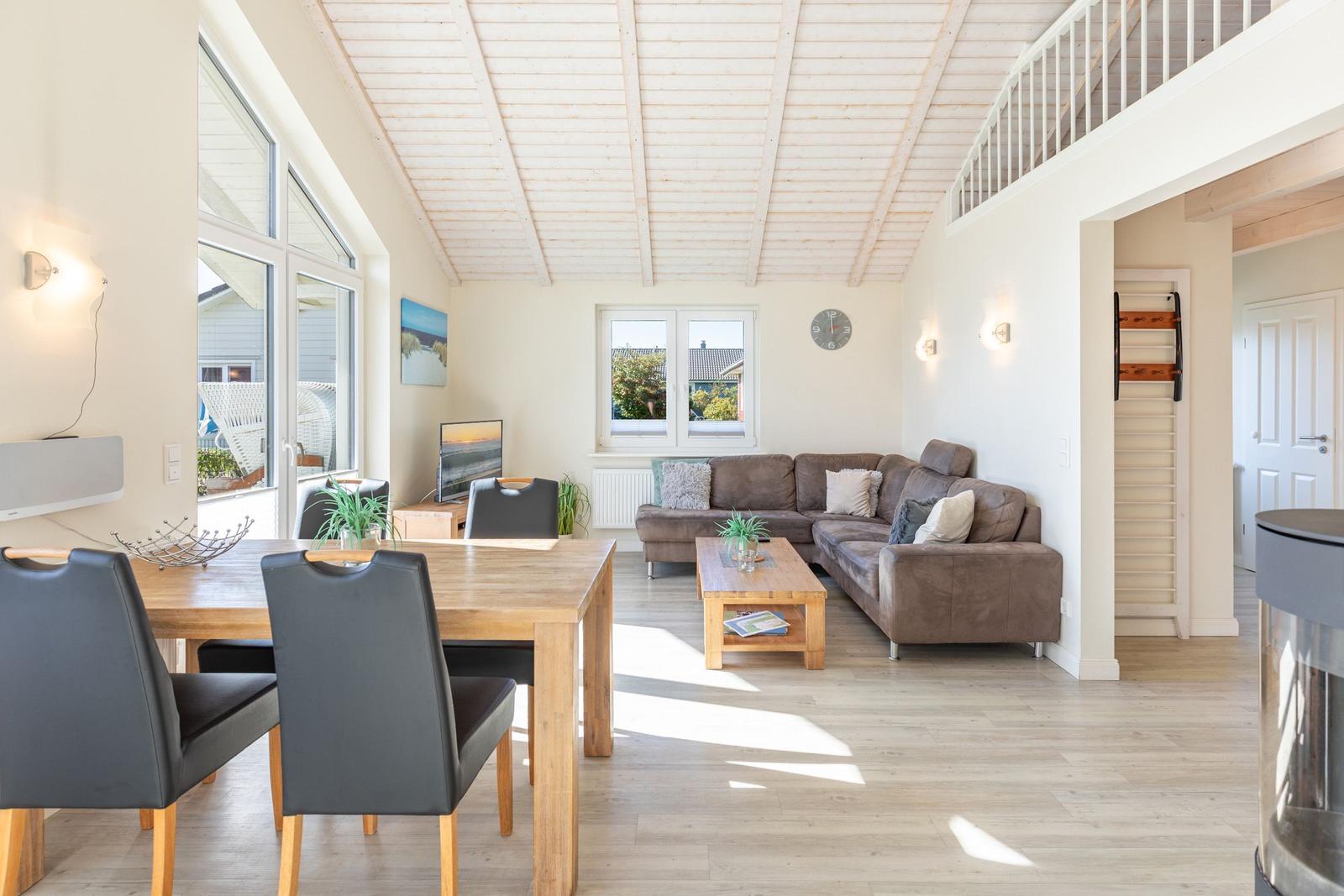 Wohn- und Essbereich mit Sofa, Esstisch und großem Fenster.