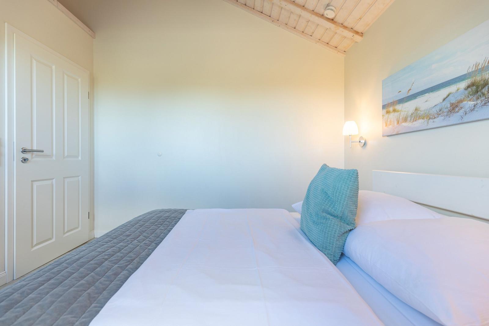 Schlafzimmer mit Bett, Wandbild und Lampen