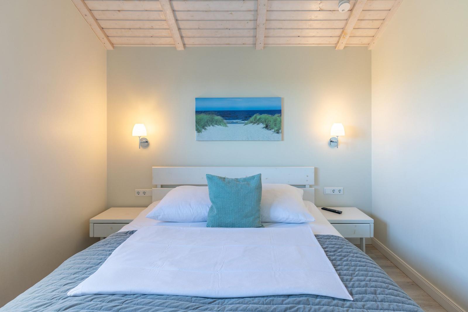 Schlafzimmer mit Bett, Nachttischen und Wandbild