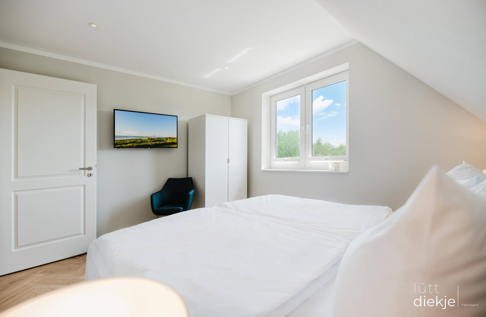 Schlafzimmer mit Bett, Fenster, Kleiderschrank und TV