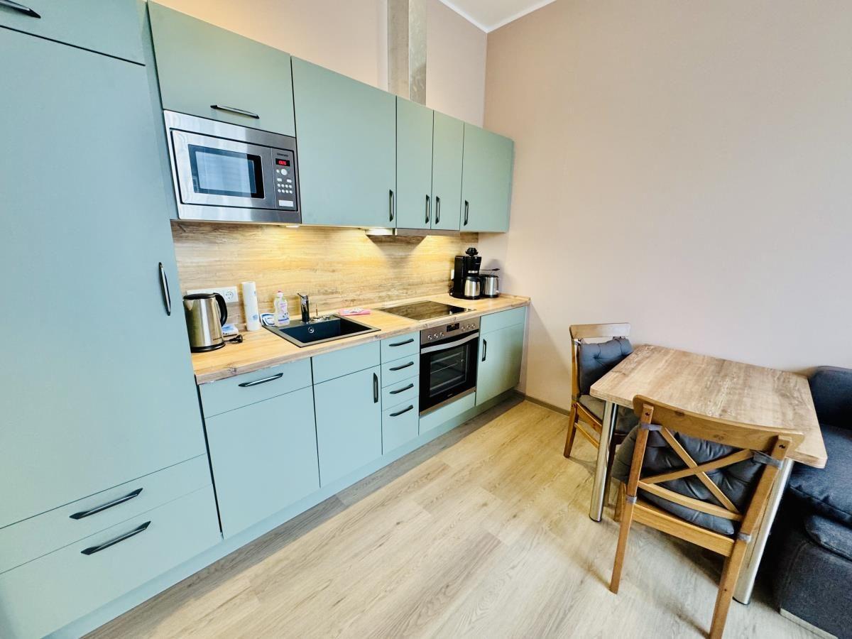 Küche mit Holztisch, Stühlen und modernen Schränken.