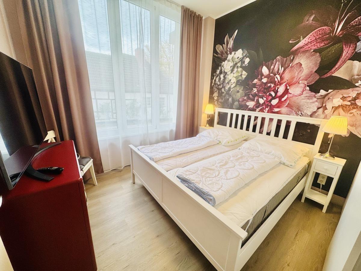 Schlafzimmer mit Bett, Nachttischen und Fenster