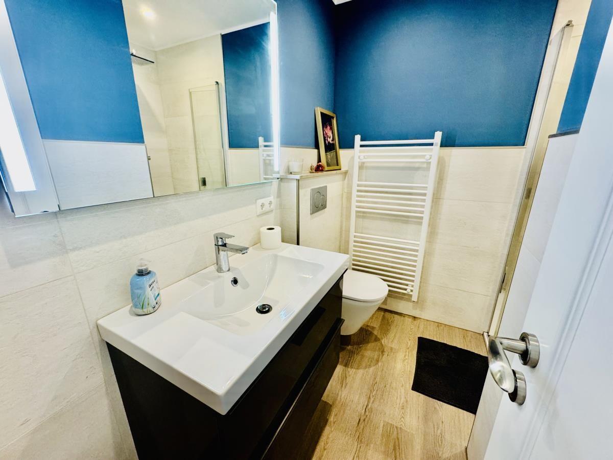 Badezimmer mit Waschbecken, Toilette und Heizkörper