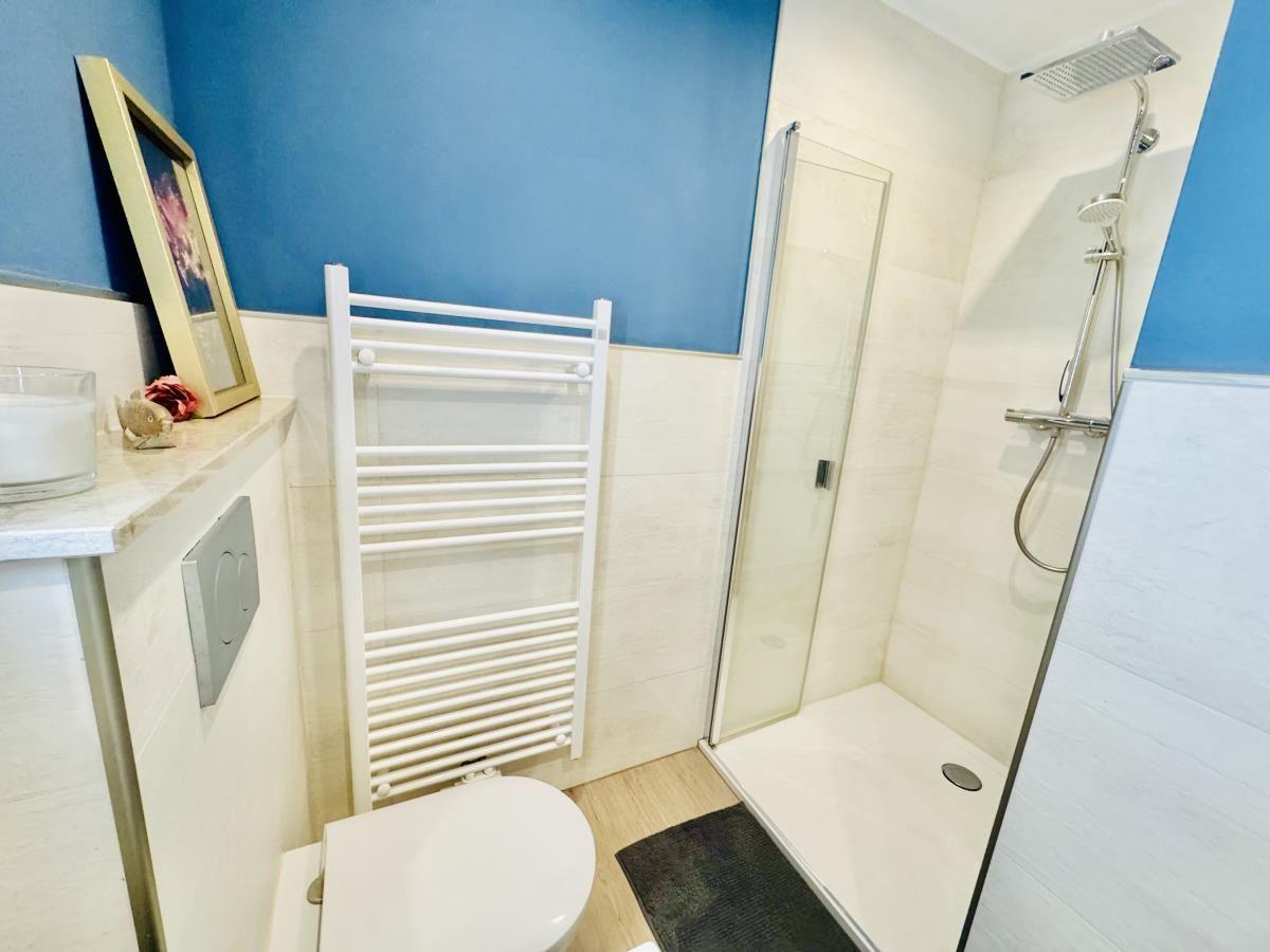 Badezimmer mit Dusche, Toilette und Heizkörper