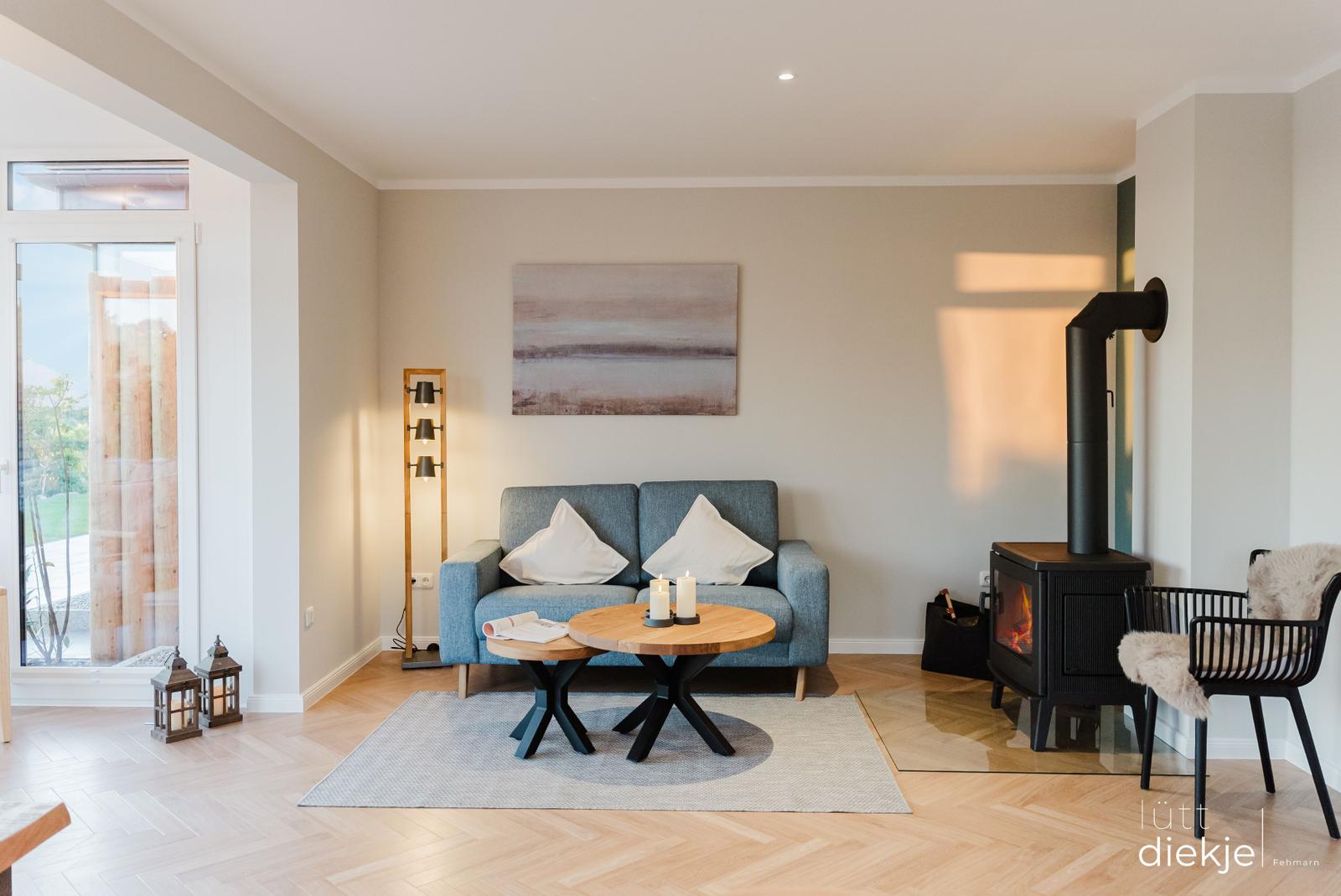 Wohnzimmer mit Sofa, Kamin und Holzboden