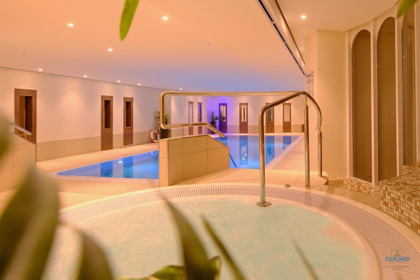 Indirekte Beleuchtung im Badebereich mit Whirlpool und Schwimmbecken.