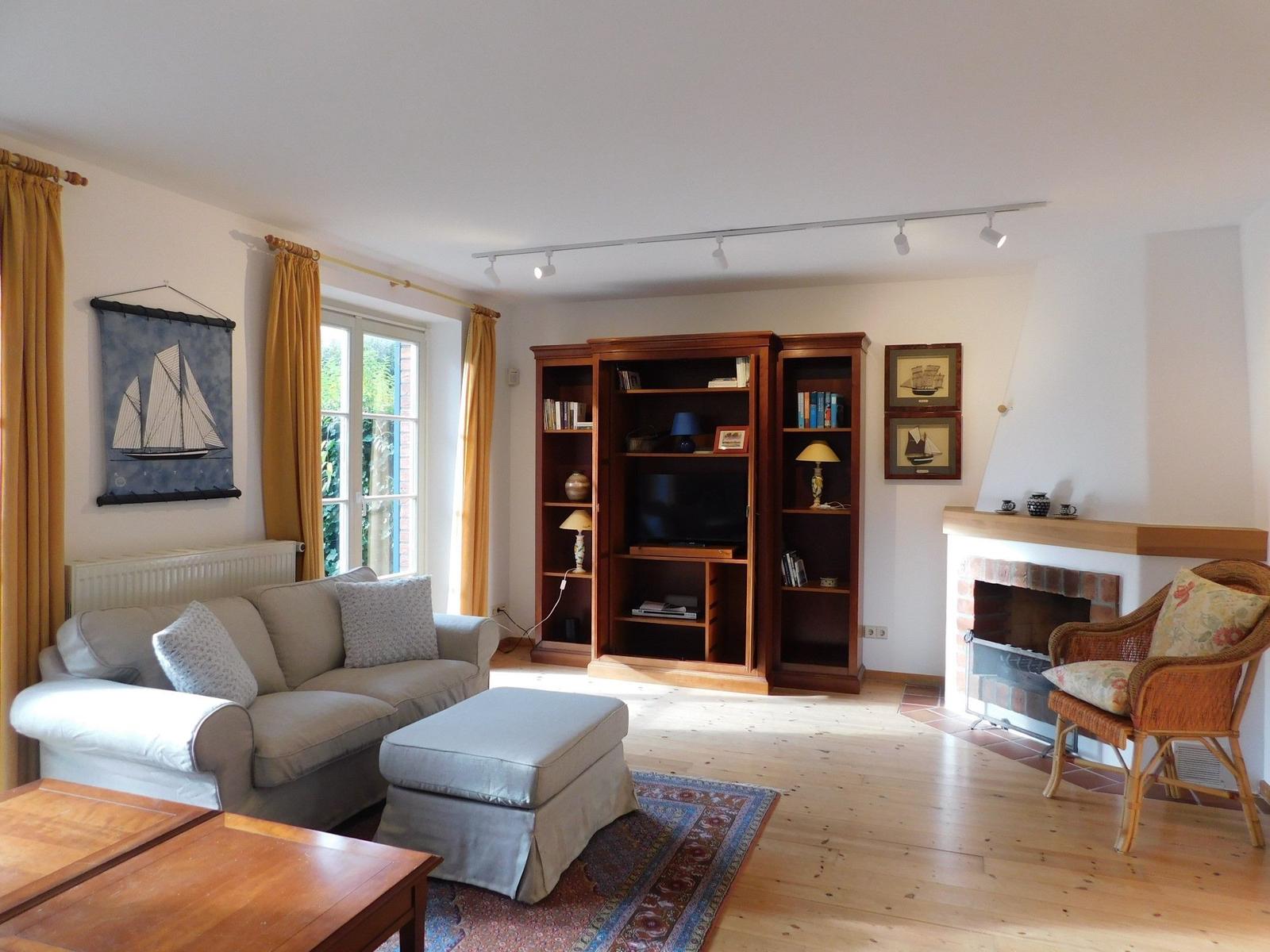 Wohnzimmer mit Sofa, Bücherregal und Kamin