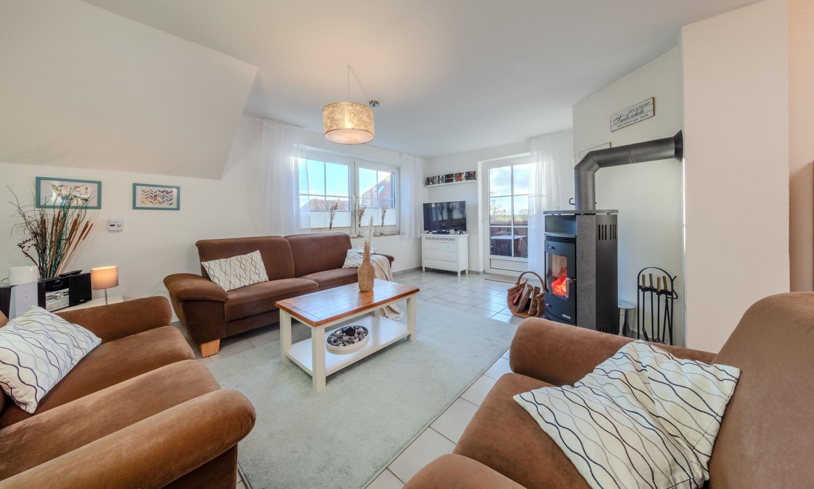 Wohnzimmer mit Sofa, Kamin und Fernseher.