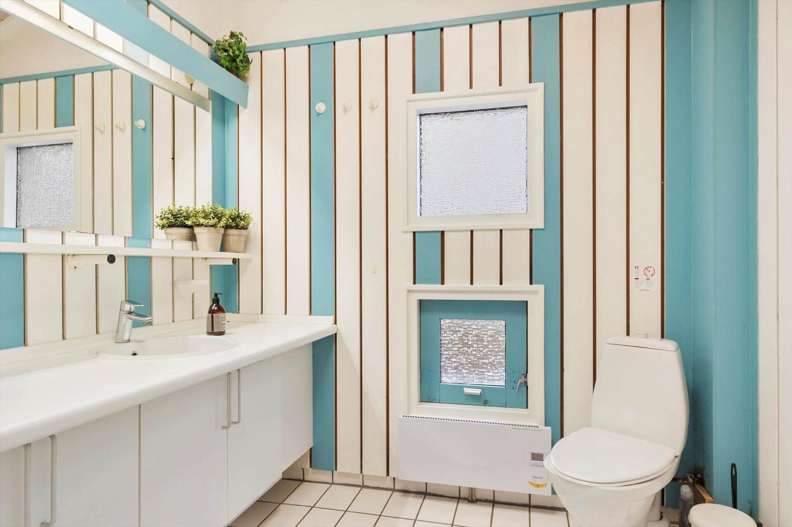 Bathroom with sink, toilet, and windows