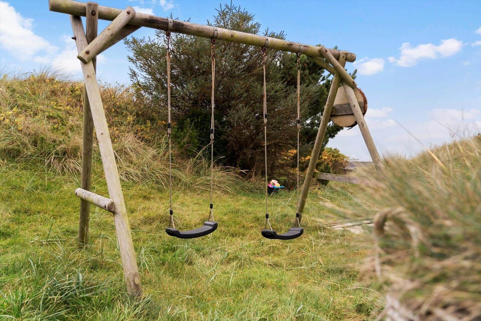 Wooden swing with two seats in the grass