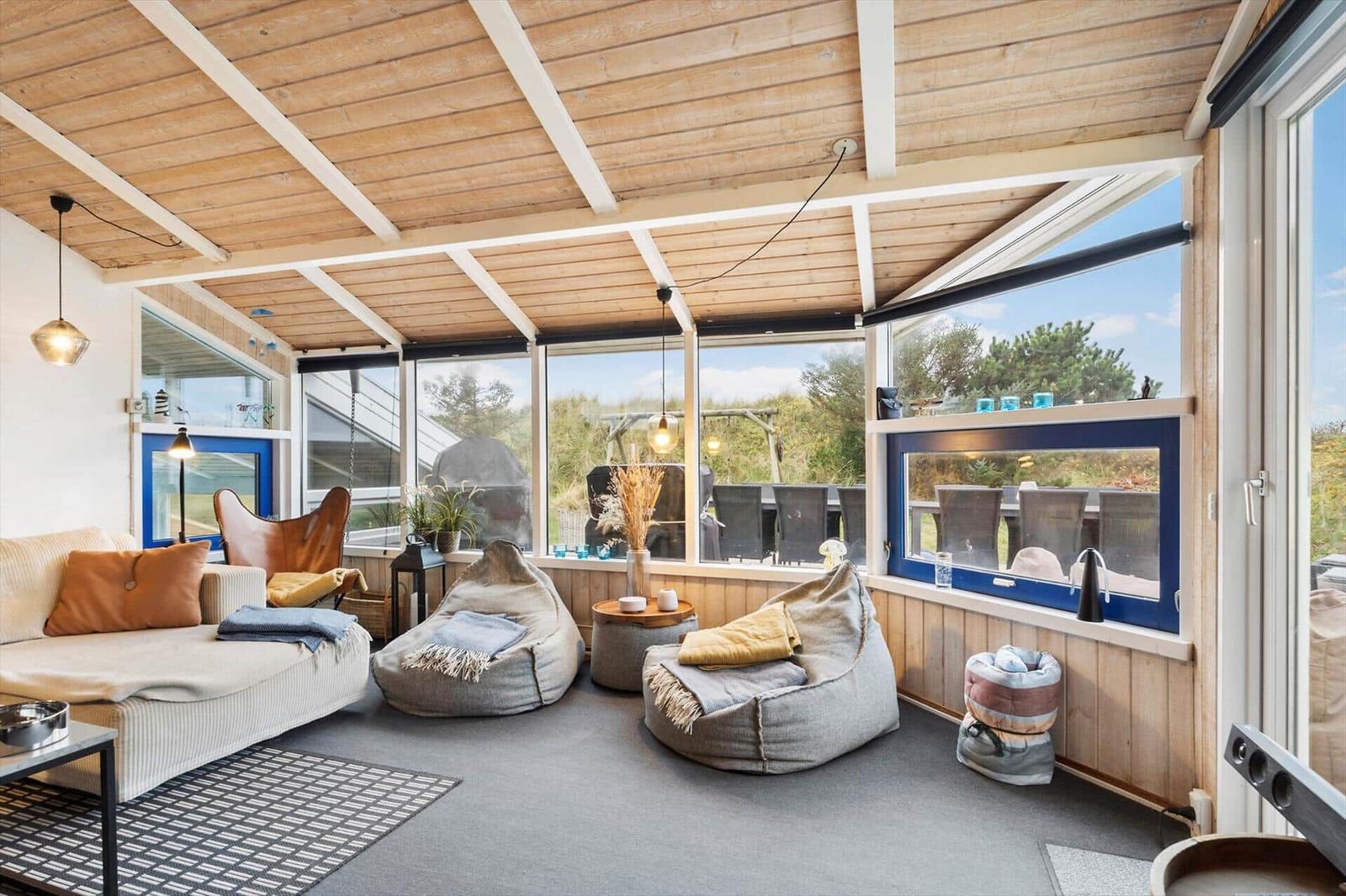 Living area with seating and large window view of the garden.