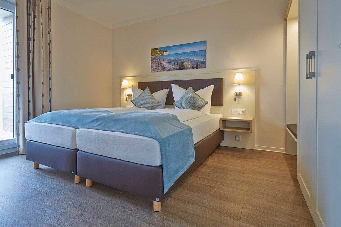 Schlafzimmer mit Doppelbett, Wandbild und Nachttischen