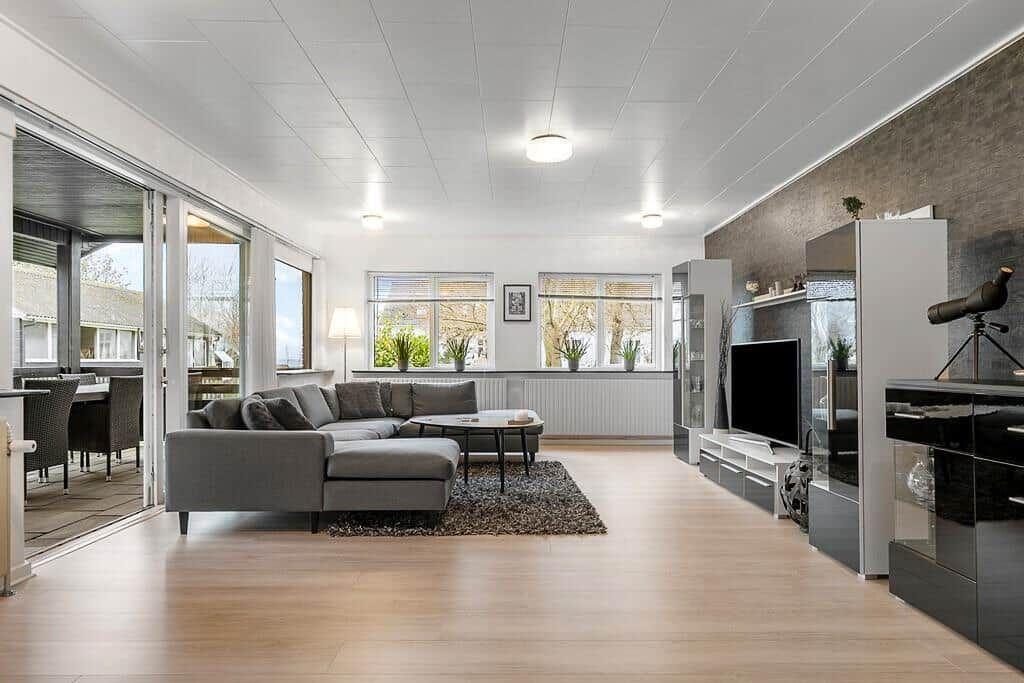 Wohnzimmer mit Sofa, Fernseher und Blick auf Terrasse