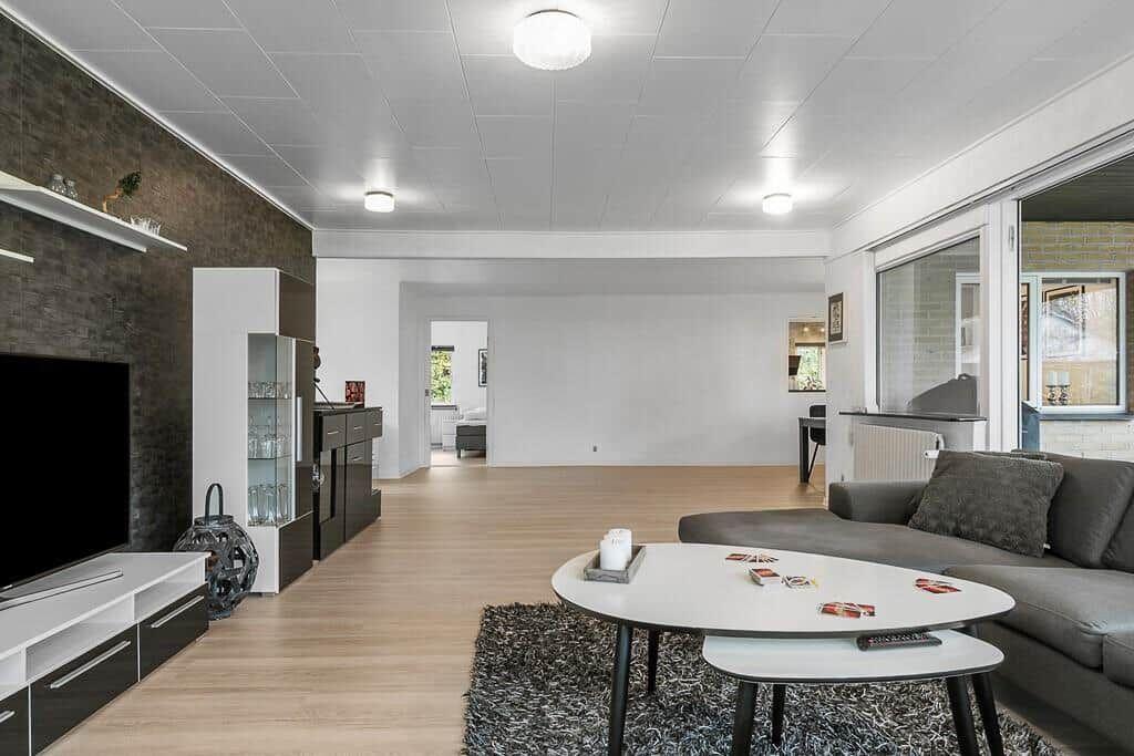 Wohnzimmer mit Sofa, Couchtisch und Fernseher an der Wand.
