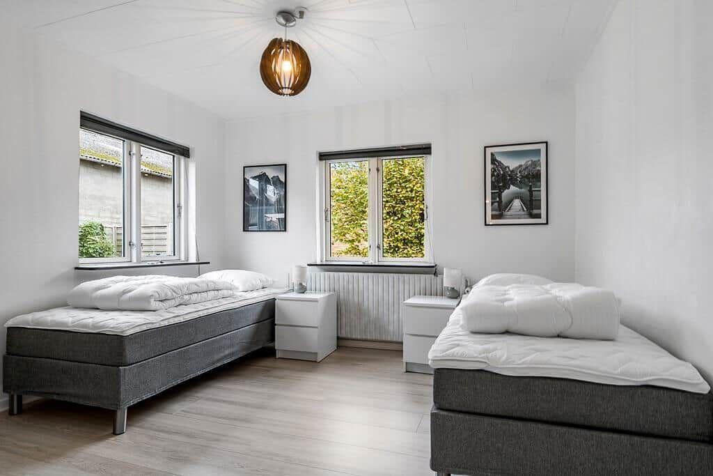 Zwei Schlafzimmer mit Fenstern und Betten.