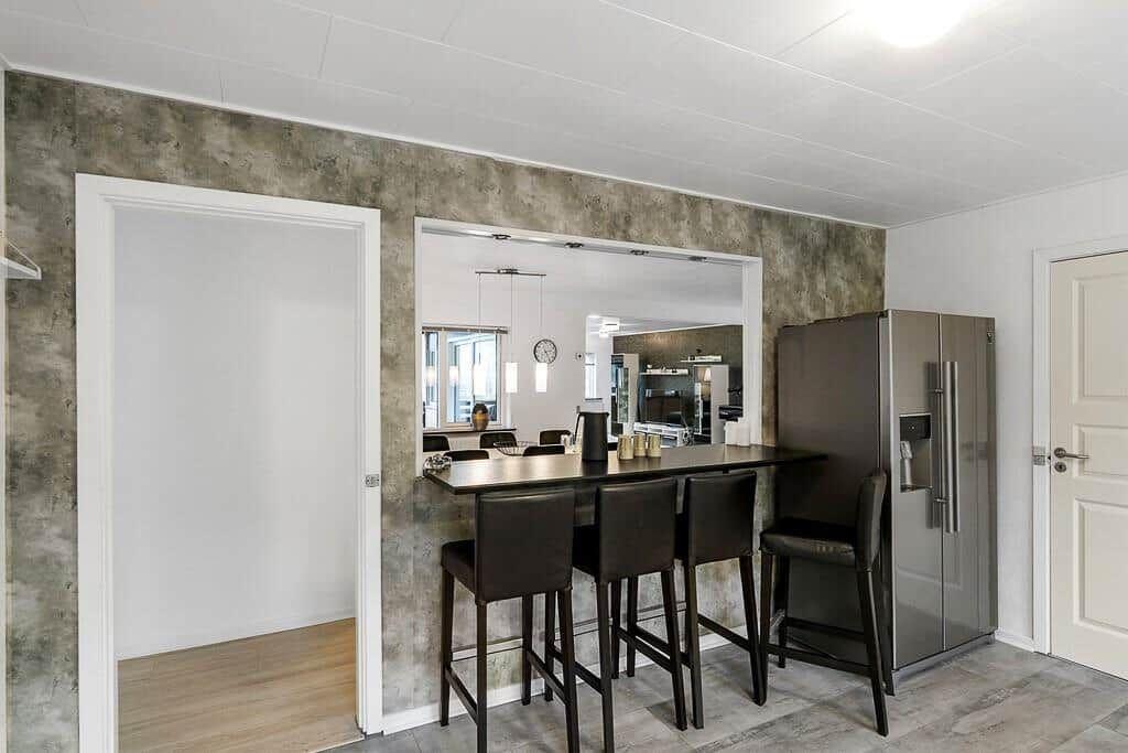 Küche mit Barhockern und Kühlschrank an der Wand