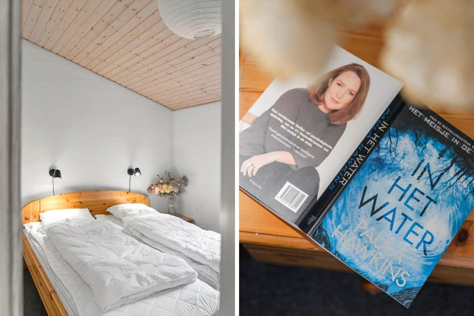 Schlafzimmer mit Holzbett und Bücherregal. Ein Buch liegt auf einem Holztisch.