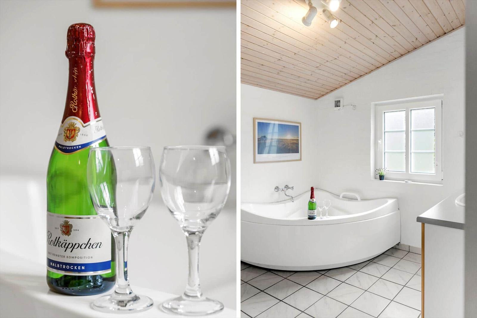 Badezimmer mit Whirlpool und Flasche Rotkäppchen. Holzdecke und Fenster.