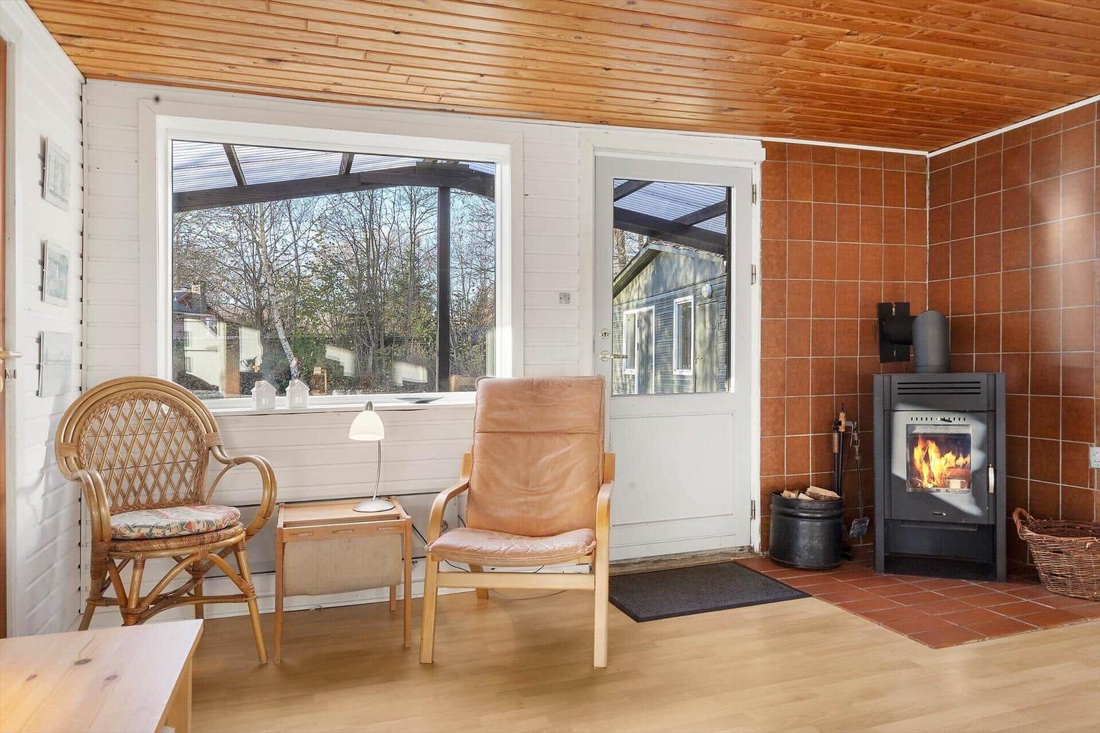 Room with seating, fireplace and window to outside.