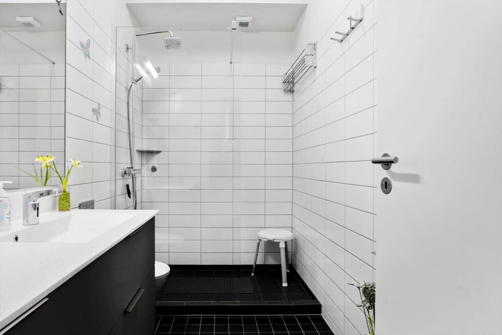 Badezimmer mit Dusche, Waschbecken und Toilette.