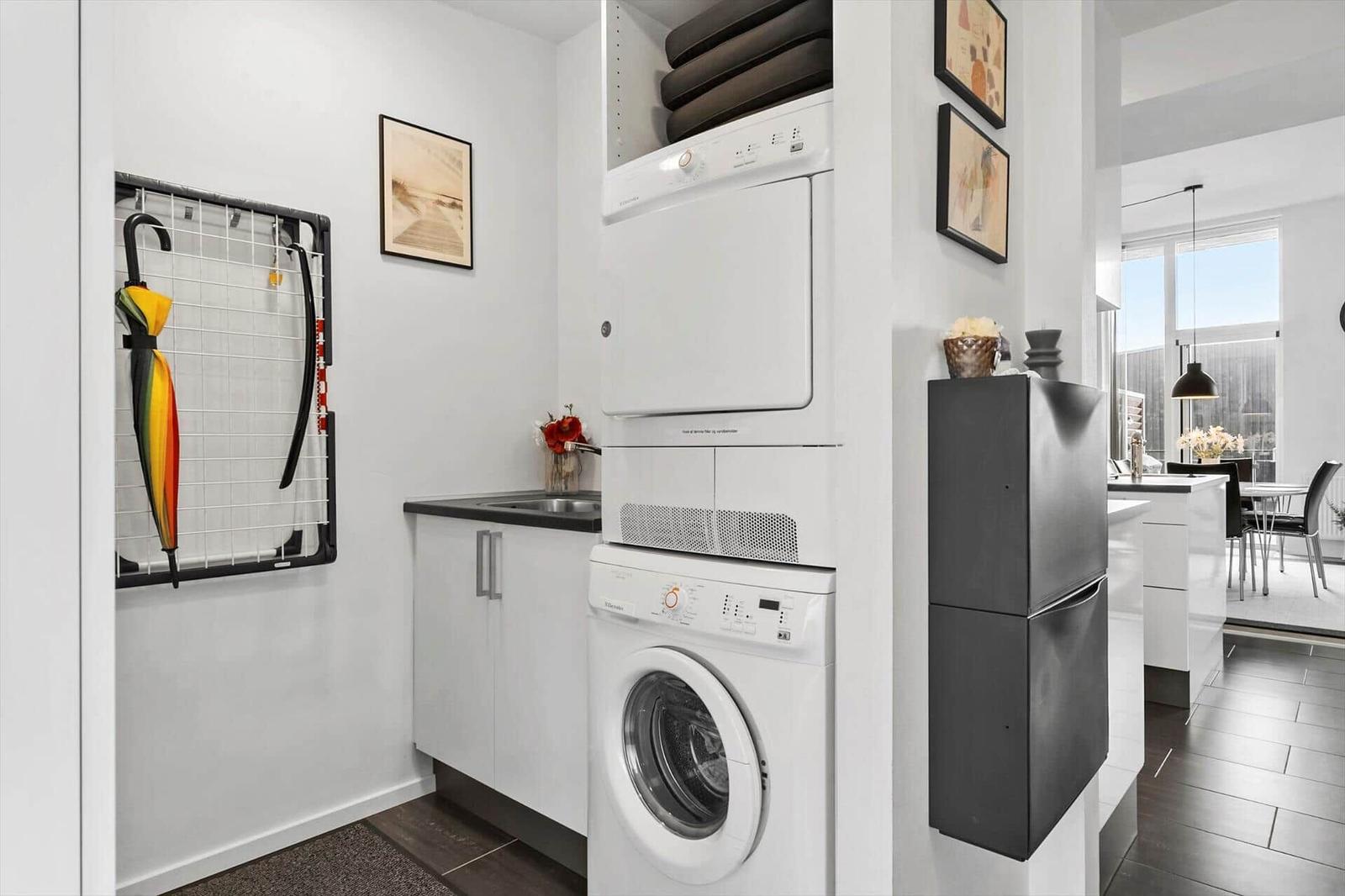 Wäscherei mit Waschmaschine und Trockner, Regal mit Decken, Regal mit Regenschirm.