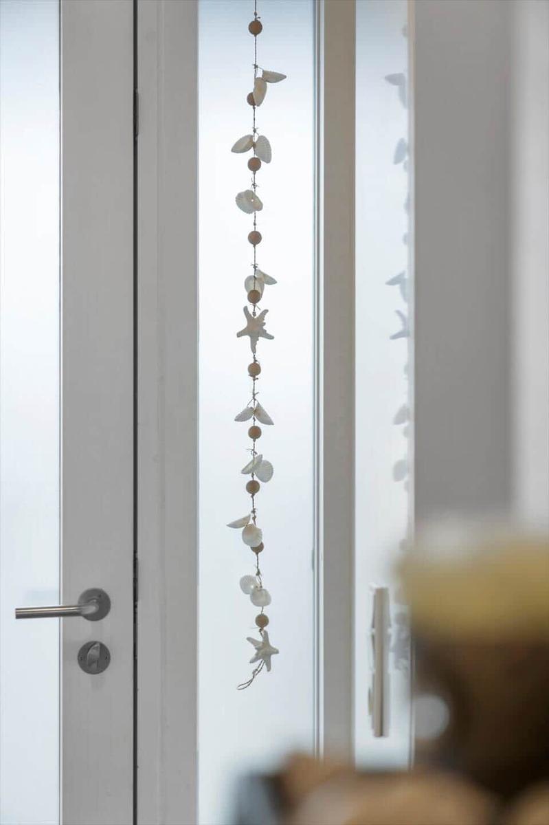 An der Tür hängt eine Girlande mit Muscheln und Seesternen.