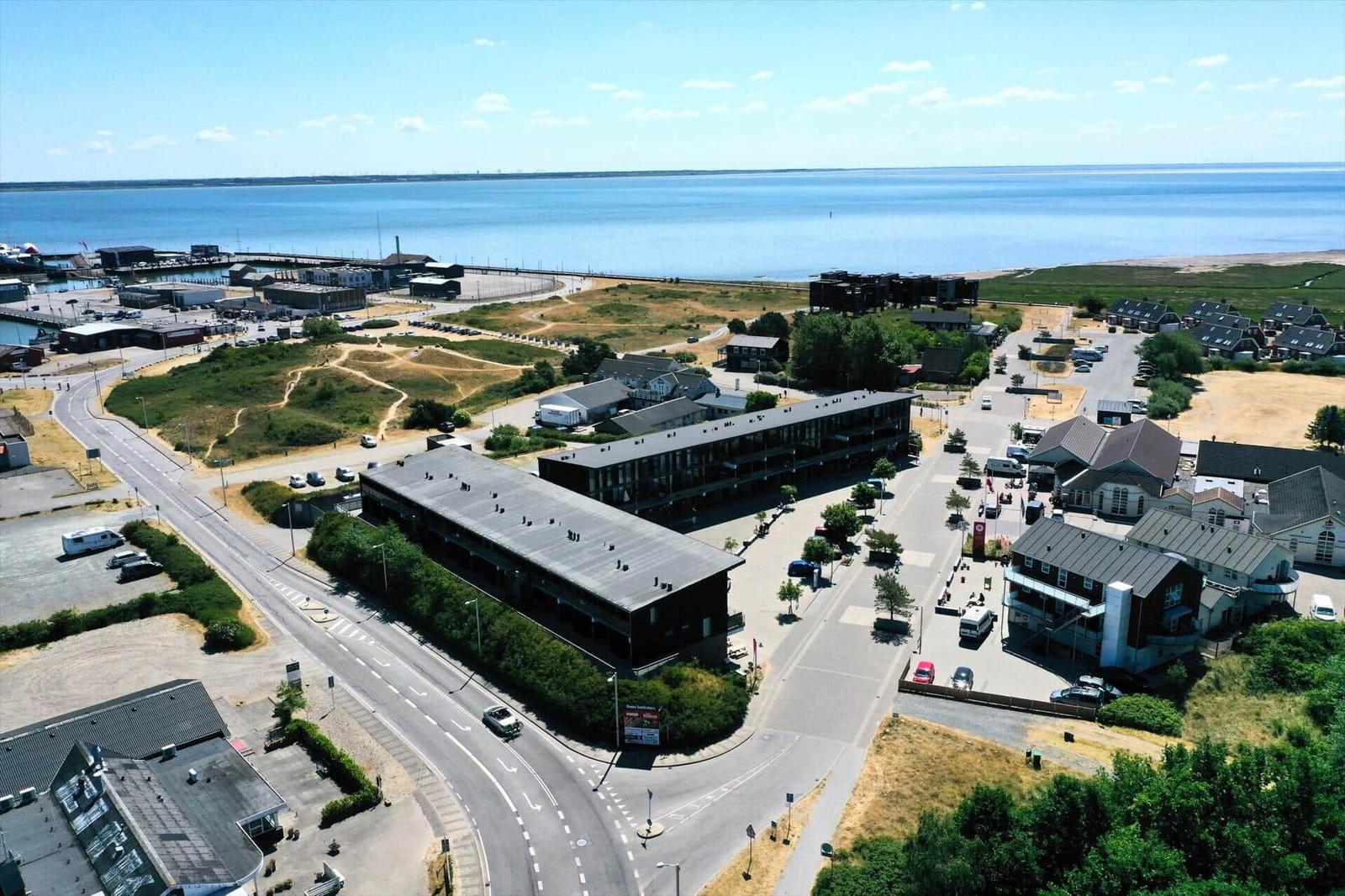 Aerial view of a coastal area with buildings, roads, and a large body of water.