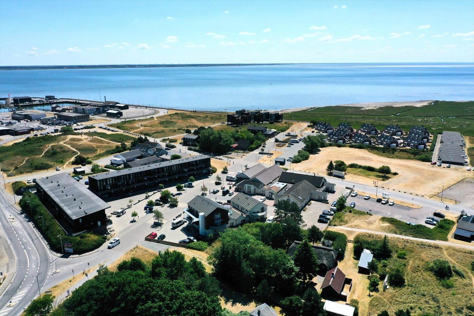 Aerial view of coastal resort with buildings, parking, and waterfront.