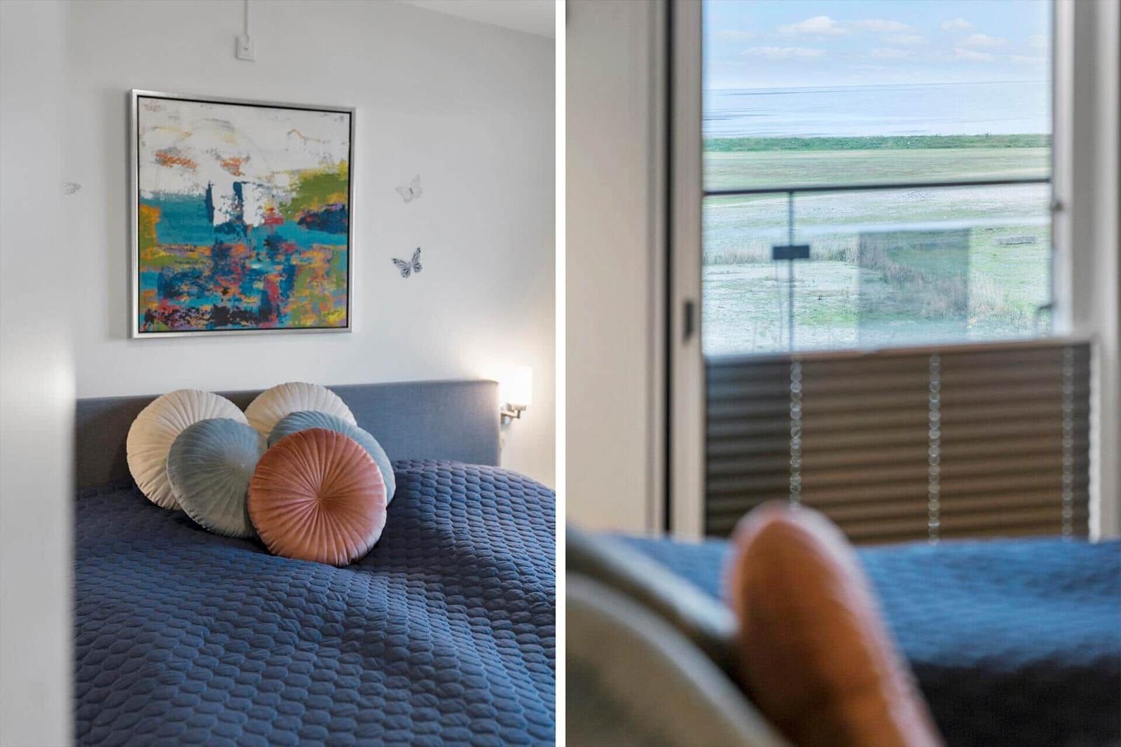 Schlafzimmer mit Bett und Blick auf Feld. Wandbild und Schmetterlinge.