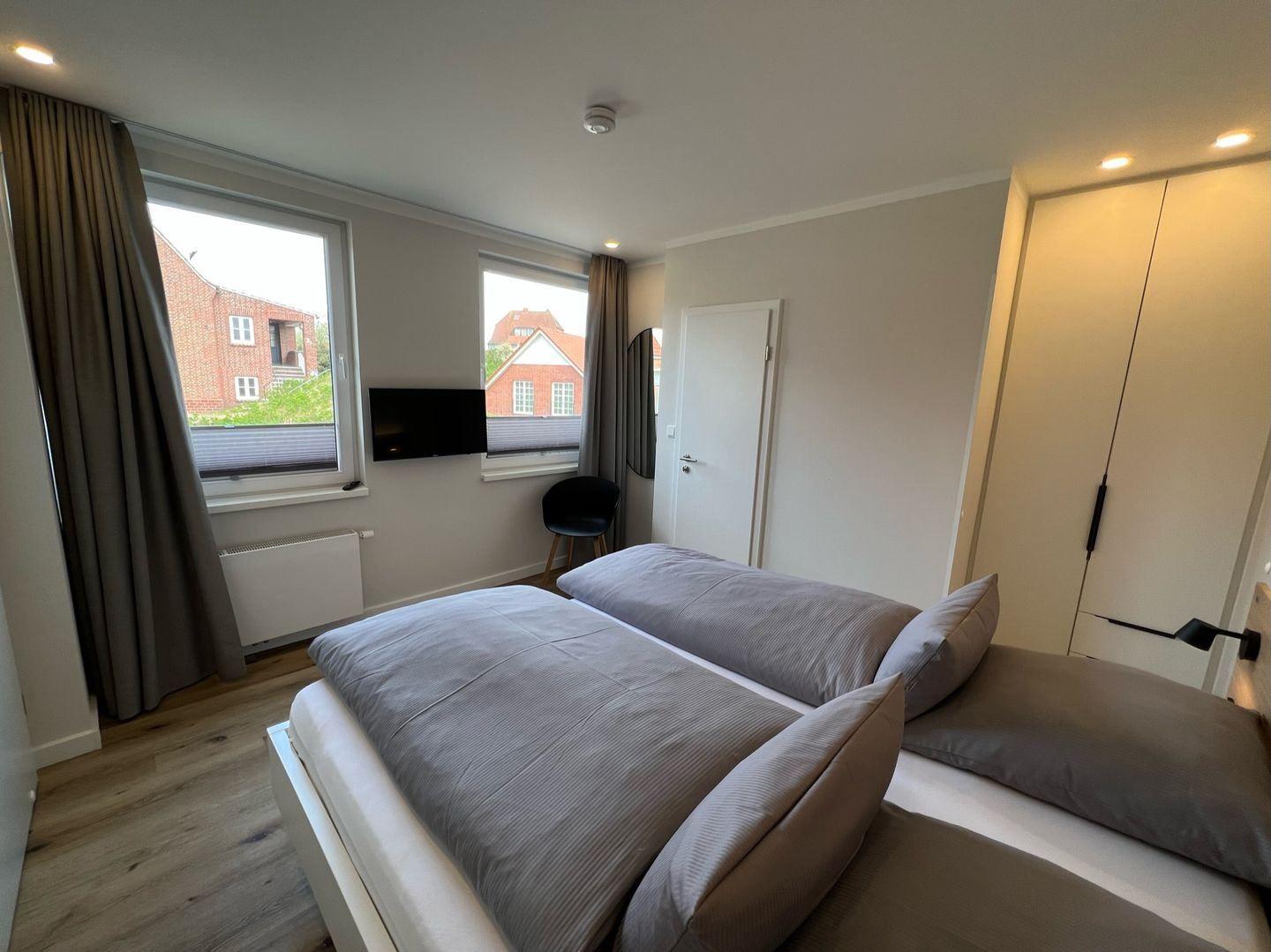 Schlafzimmer mit Doppelbett, Fenster und TV
