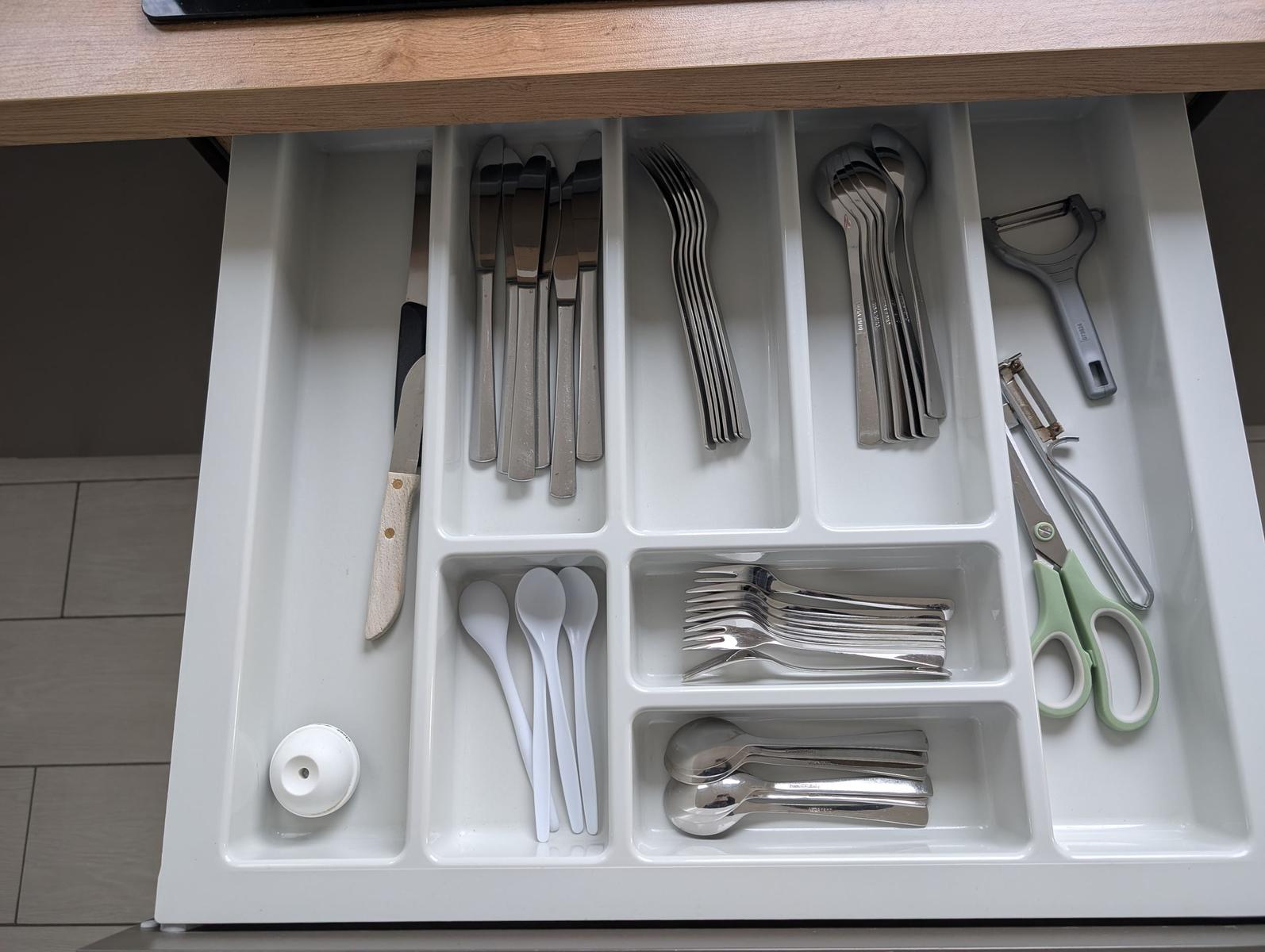 Küchenschublade mit ordentlich sortierten Besteck und Küchenutensilien.