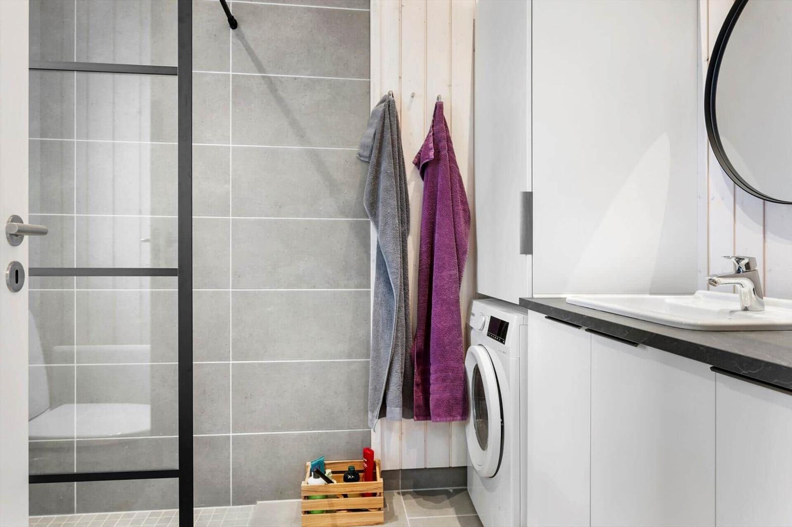 Bathroom with shower, washing machine, and sink