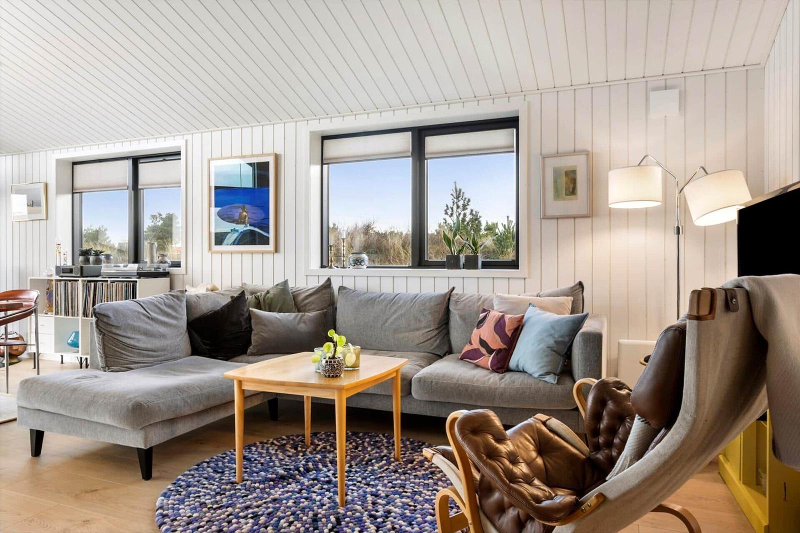 Living room with gray sofa, wooden table, and brown armchair.
